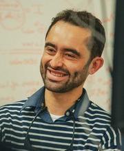 Samuel Serna Otalvo smiling in front of a white board