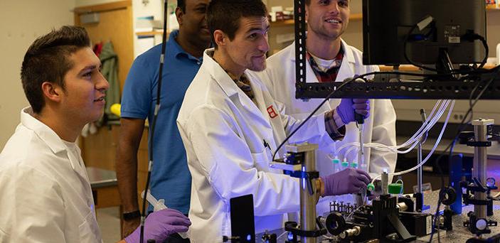 Dr. Thaya Paramanathan with 3 students in BSU's single molecule lab