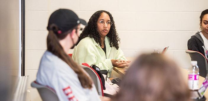 a student speaking in class while students around her listen