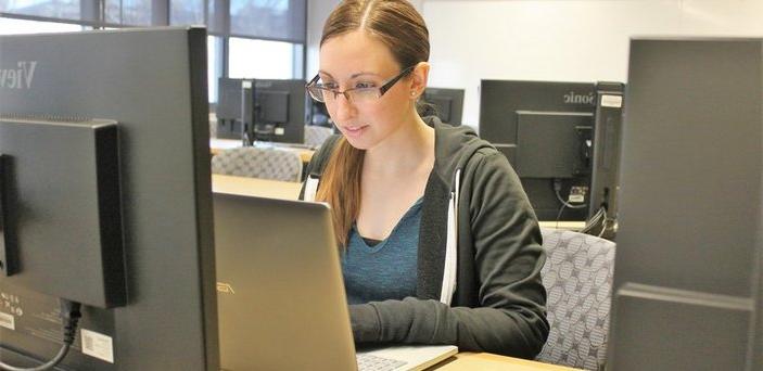 Student working on her laptop in computer lab